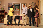 A man in a yellow T-shirt, a man sitting on a couch with a neckbrace and sunglasses, another man, a man in a cowboy hat,
       and a woman wearing a black skirt