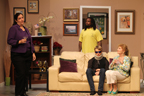 A standing woman in a purple outfit, a man in a yellow T-shirt, a man with a neckbrace and sunglasses sitting on a couch and
       a woman in a print jacket