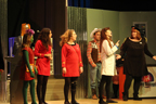 A green alien and two women in red Starfleet uniforms, a man in a cowboy hat and vest, a woman in a white lab coat and a woman in a
       black sparkly skirt