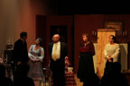 A man in a dark suit, a Victorian-dressed woman, a bald man, a woman in a dark dress and a
       young woman